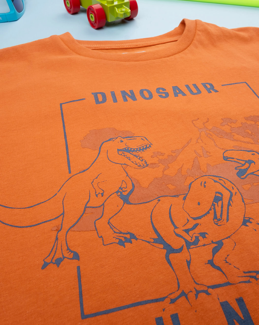 T-shirt bimbo arancione stampata dinosauri