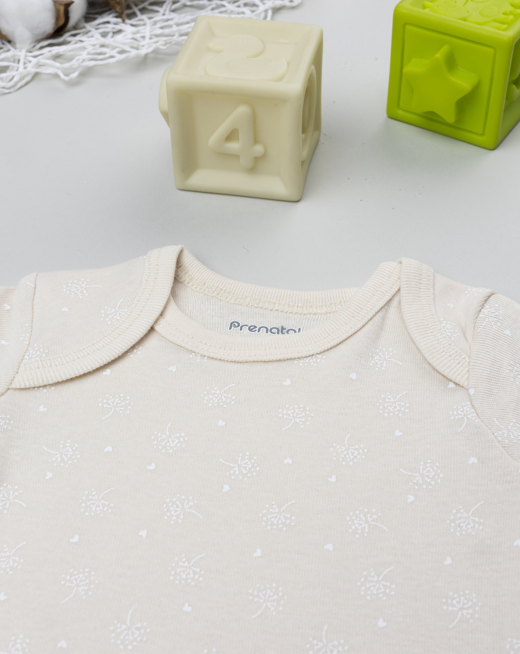 Body neonata beige con fiori allover