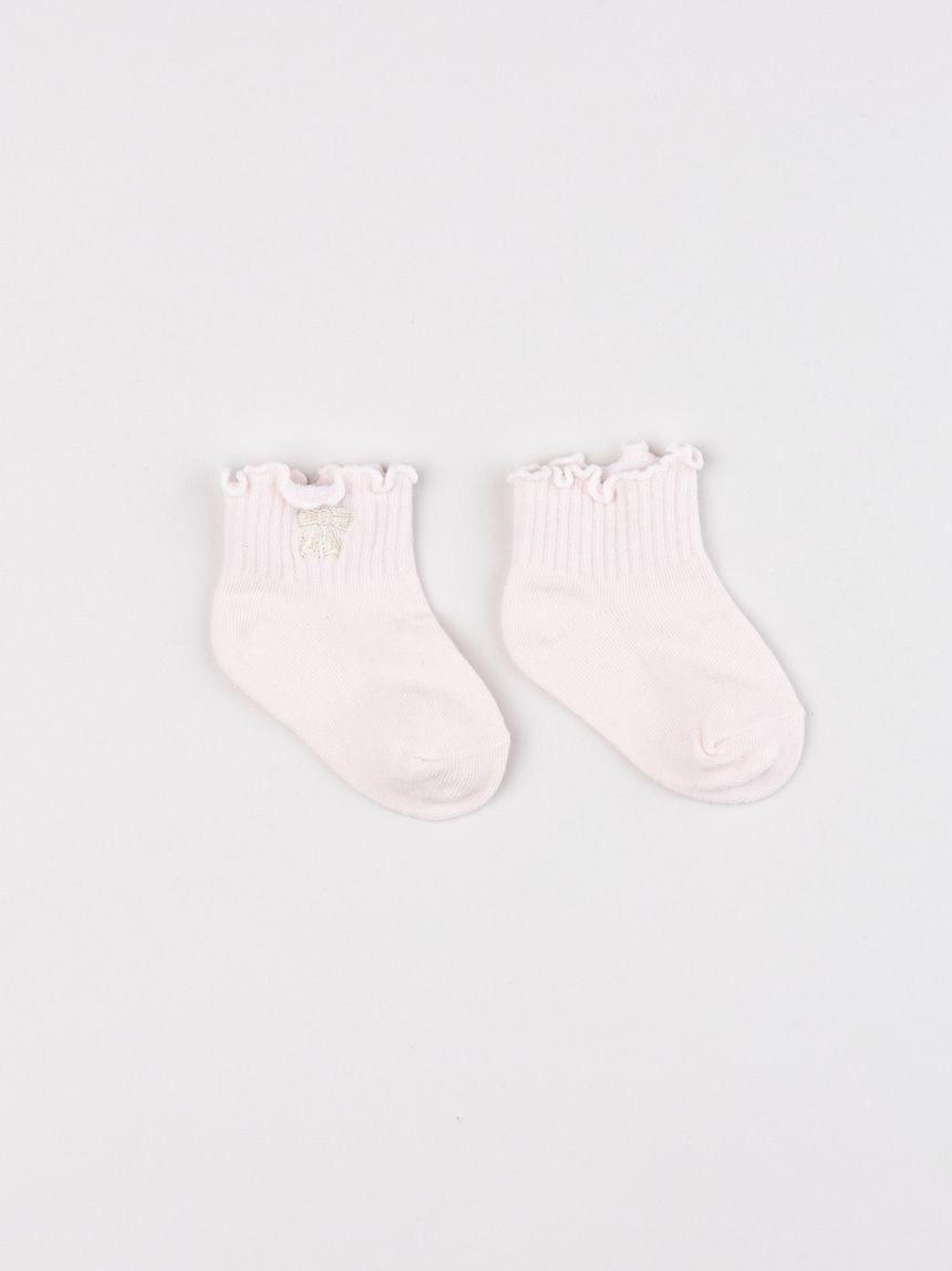 Calzini neonata rosa con bordo ondulato e fiocco