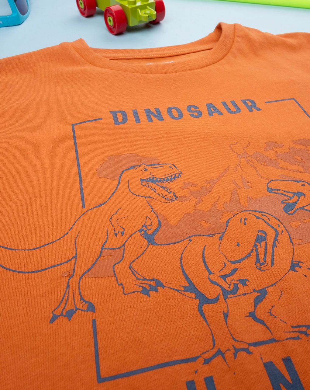 T-shirt bimbo arancione stampata dinosauri