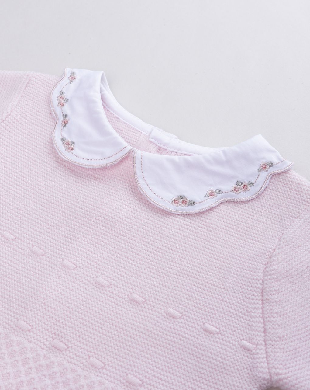 Pagliaccetto neonata in maglia rosa con colletto ricamato a fiori